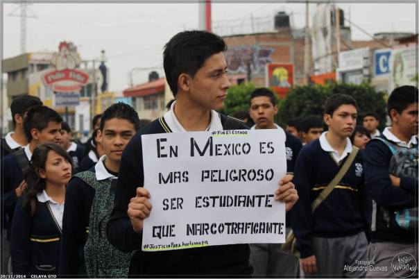 The sign the student  is holding reads: In Mexico it's more dangerous to be a student than a drug trafficker.